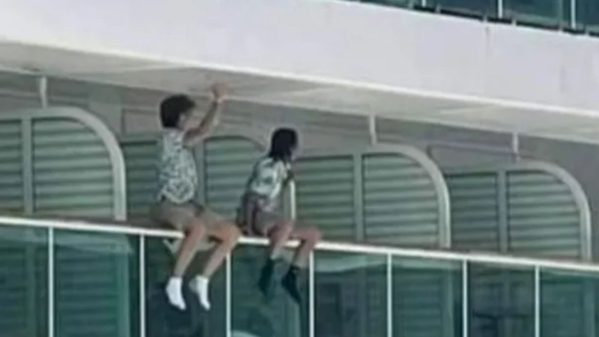 孩子们被拍到在130英尺高的游轮边上的栏杆上晃腿